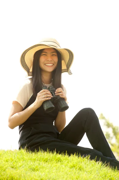 Bastante asiática joven mujer sentarse en montículo buscando binoculares  . —  Fotos de Stock