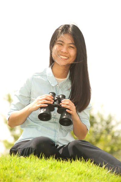 Ganska asiatisk ung kvinna sitta på högen söker kikare . — Stockfoto