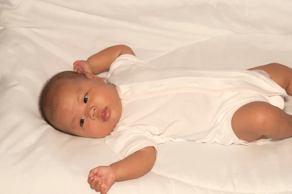 Neonato asiatico bambino ragazza sdraiato su un letto . — Foto Stock