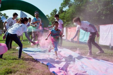 Bangkok, Tayland - 31 Ekim 2015: The Color Run sokak yarışı sırasında kimliği belirsiz insanlar görülüyor ve 31 Ekim 2015 'te büyük bir kalabalığın üzerinde eğlenceli maratonlar, parlak renkli boyalar yapıyorlar..