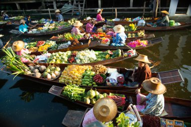 RATCHABURI, THAILAND-NOVEMBER 15, 2020: Damnoen Saduak Yüzen Piyasa sakinleri meyve satıyor, yerel yiyecekler kanalda yüzüyor, Ratchaburi, Tayland. Asya 'nın ünlü turizm beldeleri.
