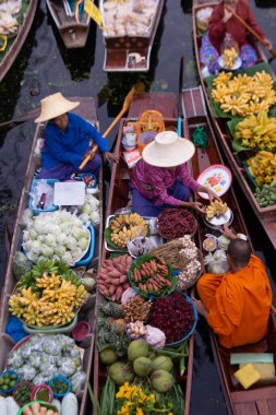 RATCHABURI, THAILAND-NOVEMBER 15, 2020: Kimliği belirsiz satıcılar Tayland ve yabancı turistler tarafından sevilen ünlü eski bir yüzen pazar olan Khlong Damnoen Saduak 'taki Budizm nedeniyle rahiplere sadaka verdiler.