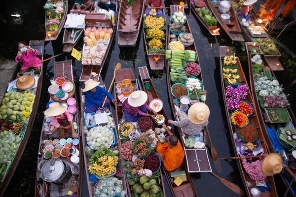 RATCHABURI, THAILAND-NOVEMBER 15, 2020: Kimliği belirsiz satıcılar Tayland ve yabancı turistler tarafından sevilen ünlü eski bir yüzen pazar olan Khlong Damnoen Saduak 'taki Budizm nedeniyle rahiplere sadaka verdiler.