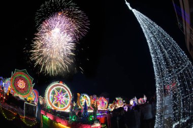 SAKON NAKHON, THAILAND - 25 ARALIK 2018: 200 'den fazla arabayla göz kamaştırıcı yıldız geçidinde Noel Baba ve melekler geçit töreninde havai fişek gösterisi. 