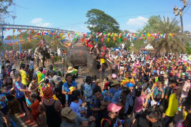 AYUTTHAYA, THAILAND - 14 Nisan 2019 Mahout ve fili neşeyle su sıçratıyor. Tayland 'ın Ayutthaya kentinde Ayutthaya Tarihi Parkı' nda Songkran Festivali 'nde (Su Festivali) genç fil eğlencesi ve mutluluğu.