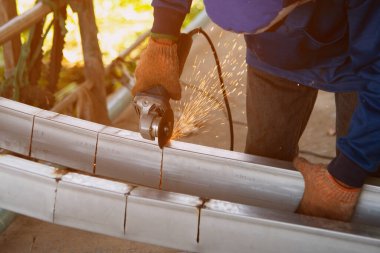 Açı öğütücü kullanan, metali kesen, bir sürü yanıp sönen kıvılcım saçan bir işçi..