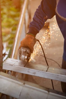 Açı öğütücü kullanan, metali kesen, bir sürü yanıp sönen kıvılcım saçan bir işçi..