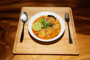 Üst manzara bir Kuzey Tayland yemeği (Khao Soi), ahşap arka planda tavuklu Körili Erişte çorbası..