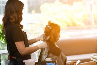 Kuaförler, COVID-19 güvenlik önlemleriyle çalışan salonlar, yüz maskesi takan bir müşterinin saçını kesiyor ve buduyor..