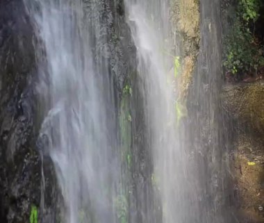 Soğuk şelale uçurumdan aşağı akar. Tayland 'ın derin ormanlarında akan berrak mavi su tabakalarıyla.