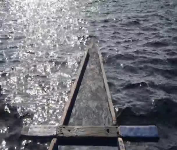 明るい太陽の光で海の波に乗ってボート 動画クリップ