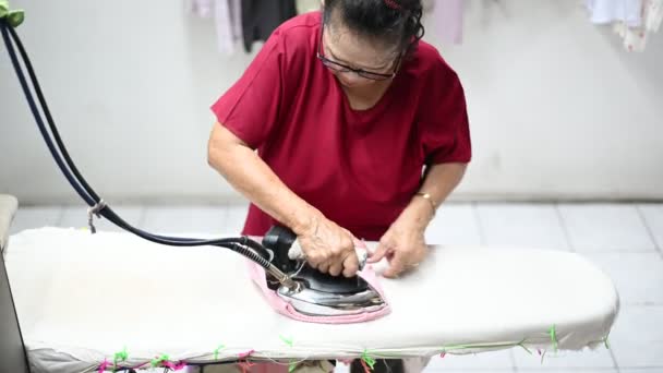Uma Mulher Idosa Asiática Que Dona Casa Está Passando Roupas — Vídeo de Stock