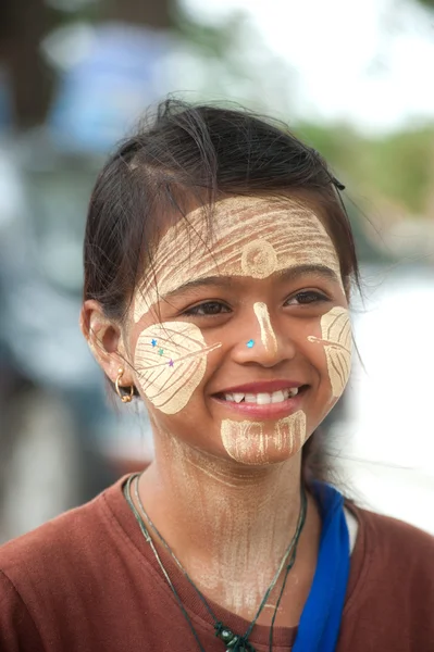 Woman with thanaka on her face in Myanmar.