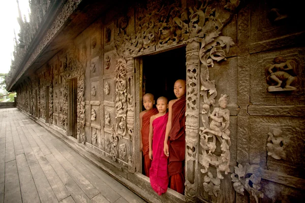 Tres jóvenes monjes de pie en el monasterio de Shwenandaw en Mandalay, Myanmar . — Foto de Stock