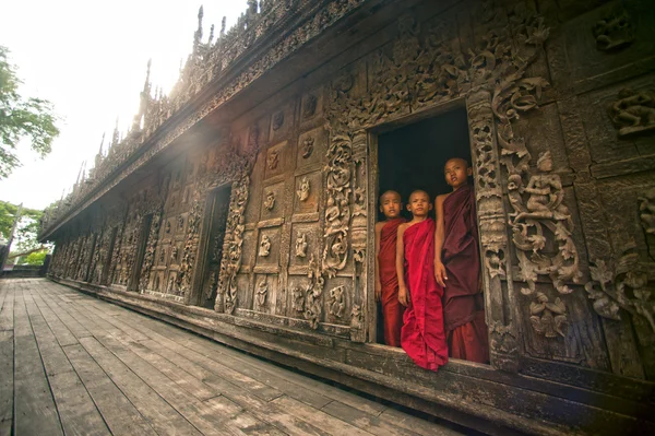 Три молодых монаха стоят в монастыре Швенандо в Мандалае, Мьянма . — стоковое фото