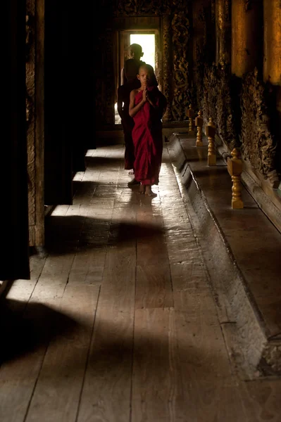 Drie jonge monniken wandelen in het Shwenandaw klooster in Mandalay, Myanmar. — Stockfoto