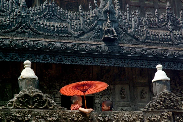 Ung munk innehar paraply i Shwenandaw kloster i Mandalay, Myanmar. — Stockfoto