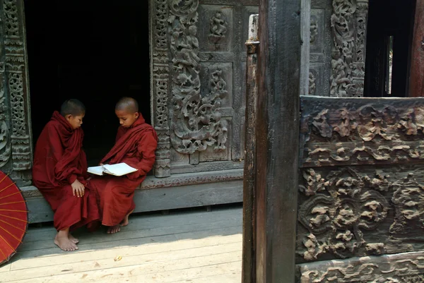 Fiatal monks Olvasson egy könyvet a Shwenandaw kolostor a Mandalay, M — Stock Fotó
