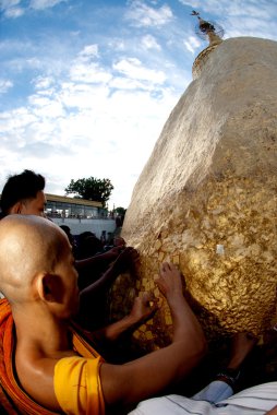 People offerings of gold for Kyaiktiyo Pagoda.Myanmar. clipart