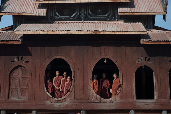 Junge Mönche am Fenster des nyan shwe kgua Tempels. — Stockfoto