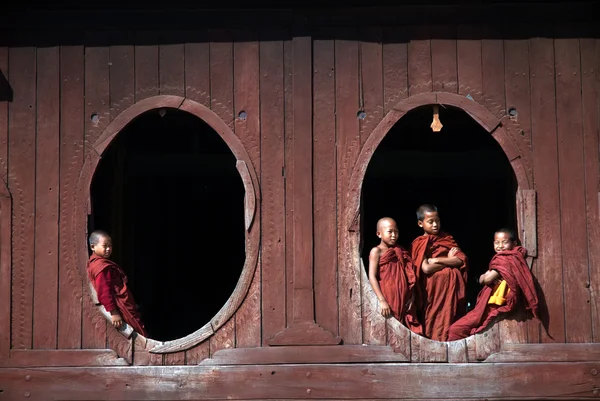 Junge Mönche am Fenster des nyan shwe kgua Tempels. — Stockfoto