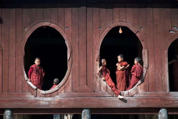 Young monks at window of Nyan Shwe Kgua temple . — Stock Photo, Image