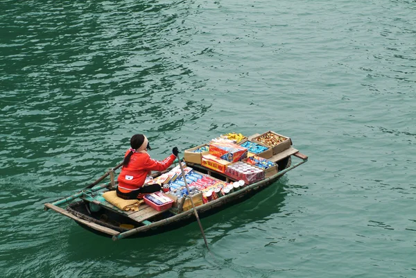 Femme vietnamienne vendant des marchandises et des collations sur son bateau . — Photo