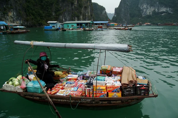 Femme vietnamienne vendant des marchandises et des collations sur son bateau . — Photo