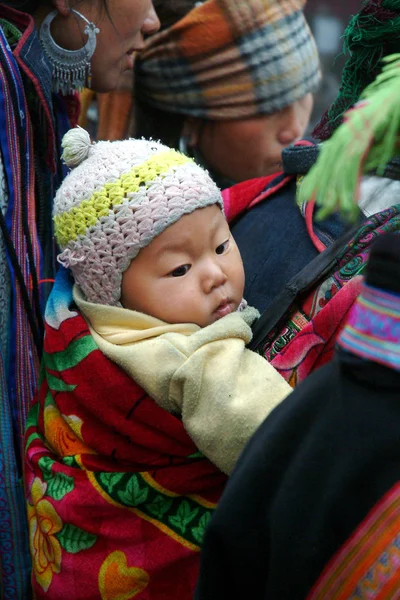 Hmong woman carrying child and wearing traditional attire. — Stock Photo, Image