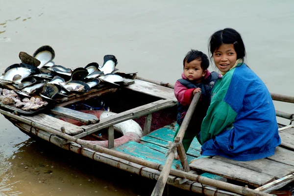 Irmã vietnamita e irmão flutuando vendendo concha na Baía de Halong, na província de Quang Ninh, Vietnã . — Fotografia de Stock