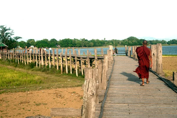 Monniken en bezoekers wandelen op de U-Bein Bridge, Myanmar. — Stockfoto