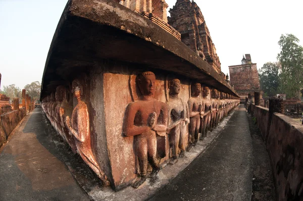 Skupina stojí starobylé sochy Buddhů v pagoda v chrámu Wat Mahatat. — Stock fotografie