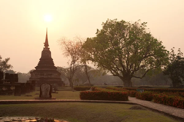 Wat Mahathat templo en la luz del sol en la noche en el parque histórico de Sukhothai . — Foto de Stock