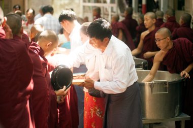 Bir Budist rahip Myanmar ile sadaka veren halklar.