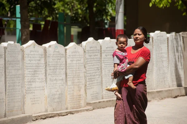 Burmese mother and son through the ranks of the stone slabs of t — Stock Photo, Image