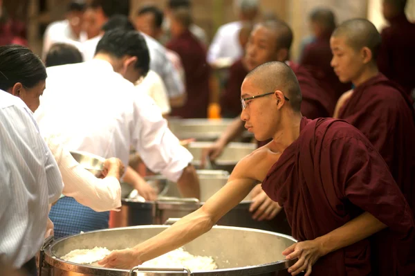 Volkeren met aalmoezen geven een boeddhistische monnik in Myanmar. — Stockfoto