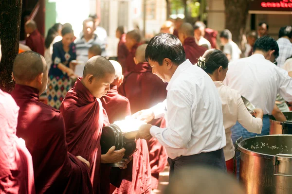 Dando limosna a un monje budista en Myanmar . — Foto de Stock