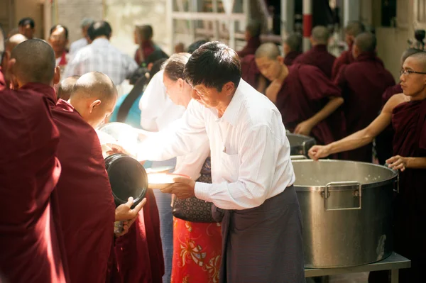 Dando limosna a un monje budista en Myanmar . — Foto de Stock