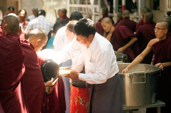 Dando limosna a un monje budista en Myanmar . — Foto de Stock