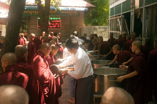 Les peuples donnent avec l'aumône à un moine bouddhiste au Myanmar . — Photo