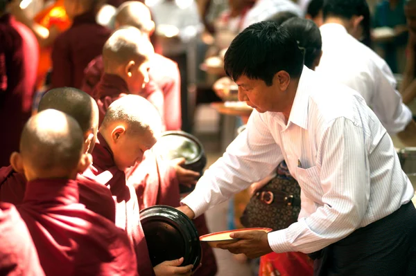 Dando limosna a un monje budista en Myanmar . — Foto de Stock