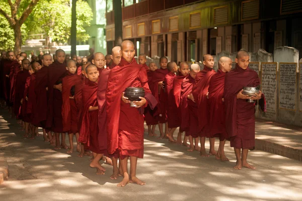 Reihe buddhistischer Mönche wartet in Myanmar auf das Mittagessen. — Stockfoto