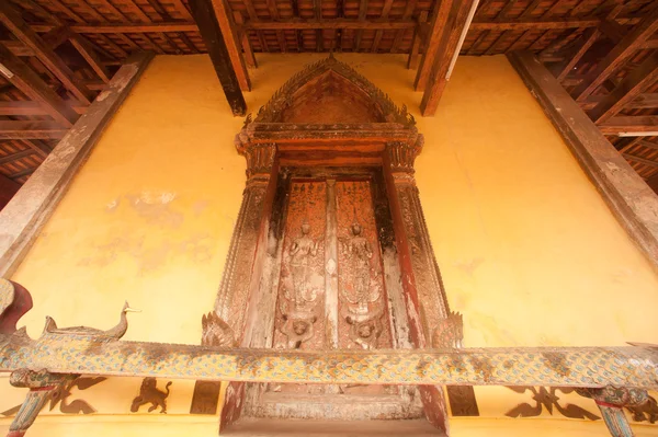 Oude Laos kunst hout snijwerk op kerk in Si Saket tempel in de stad in Vientiane, Laos. — Stockfoto