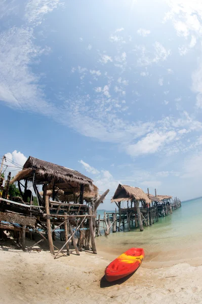 Kanu am Strand und traditionelle Holzbrücke. — Stockfoto