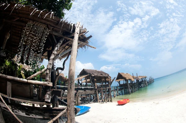 Kano op het strand en traditionele houten brug. — Stockfoto