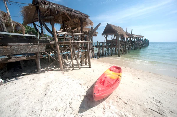 Canoe on the beach and traditional wooden bridge. — Stock Photo, Image