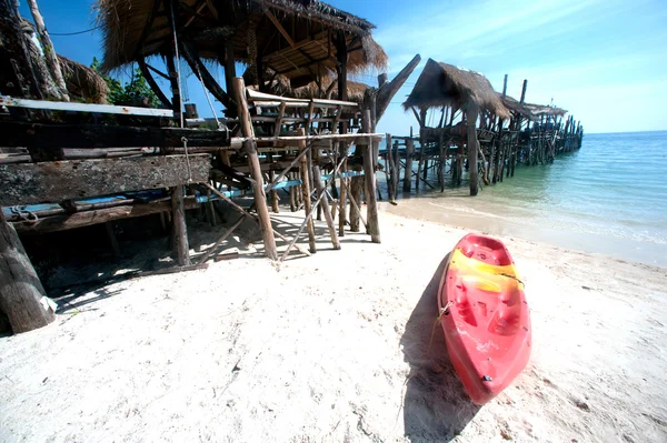 Canoe on the beach and traditional wooden bridge. — Stock Photo, Image