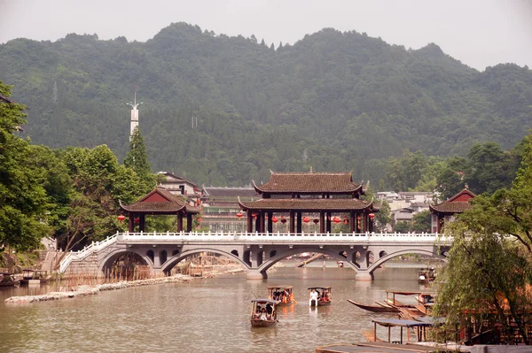 Turistit rentoutua, ottaa veneretki joen Fenghuang ancie — kuvapankkivalokuva