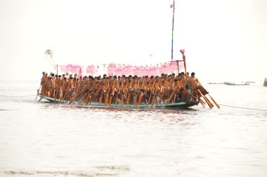 Peoples paddle by legs in Phaung Daw Oo Pagoda festival,Myanmar.
