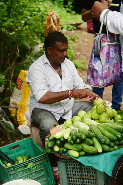 ОРАНГАБУД, Индия - 24 августа 2025 года: Неизвестные жители деревни продают огурцы туристам в пещерах Аджанты, считающихся самыми красивыми и древними буддийскими пещерными храмами в мире.